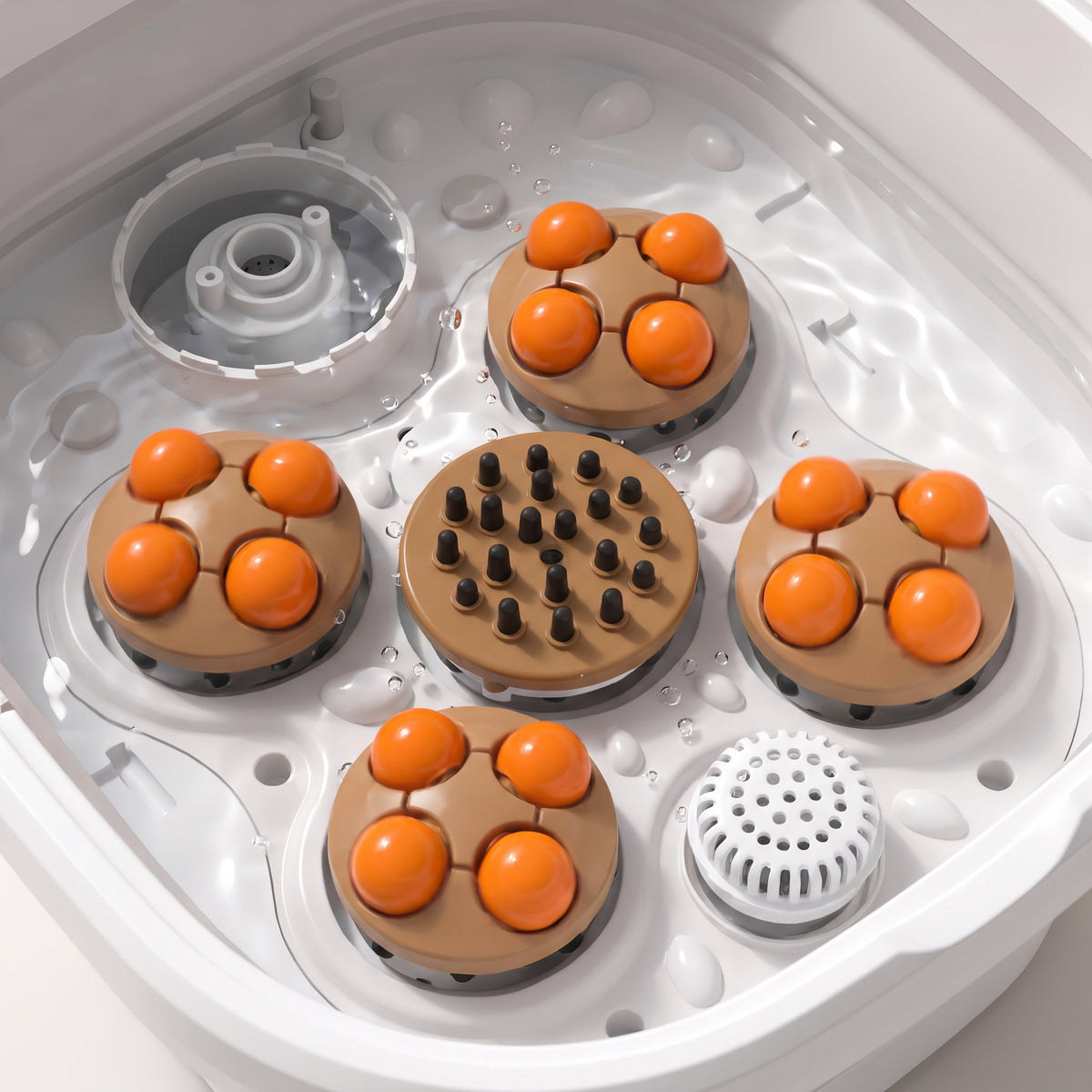 Vue du dessus des 4 plateaux motorisés à boules orange et du disque à picots, sous l'eau claire du bain de pieds
