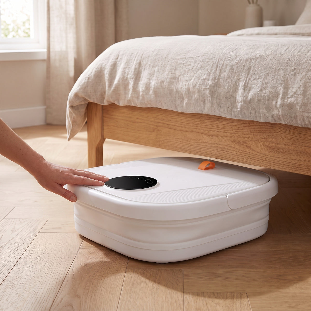 Bain de pieds replié à plat, glissé sous un lit