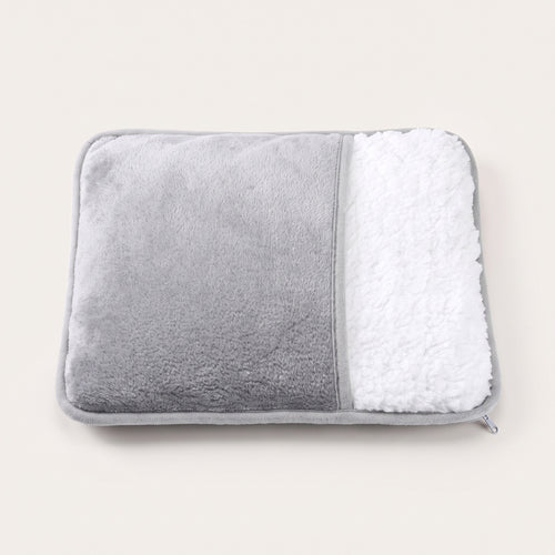 Chauffe-pieds vu de face : dessus en flanelle grise, ouverture en peluche blanche bouclée, fermeture éclair dans le coin