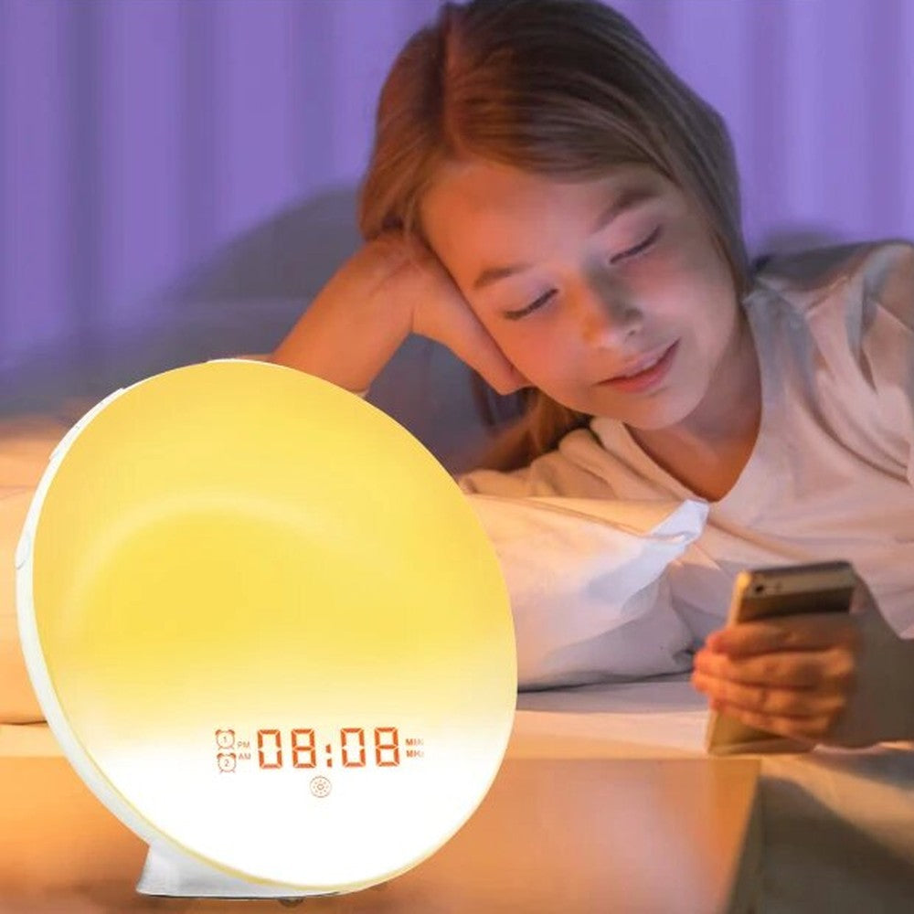 Réveil utilisé en veilleuse le soir, lumière douce au bord du lit