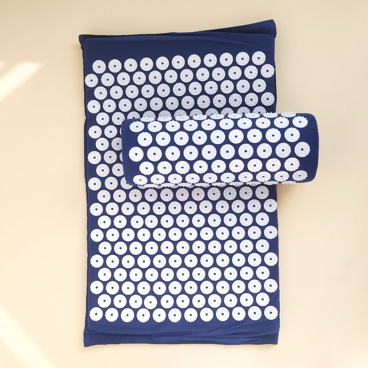 Tapis d'acupression bleu nuit à disques blancs, avec son coussin pour la nuque posé dessus